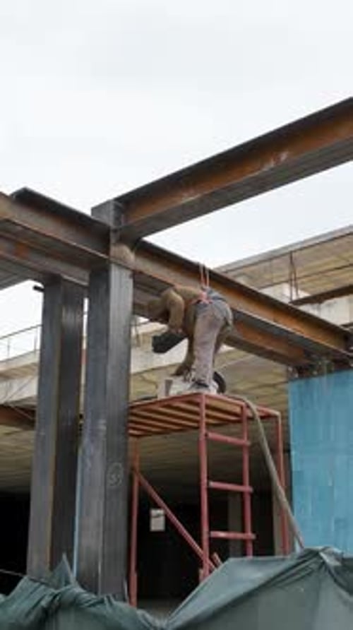 Vídeo vertical: perspectiva aérea de los trabajos de construcción: soldadura de construcciones metálicas en un mega centro comercial