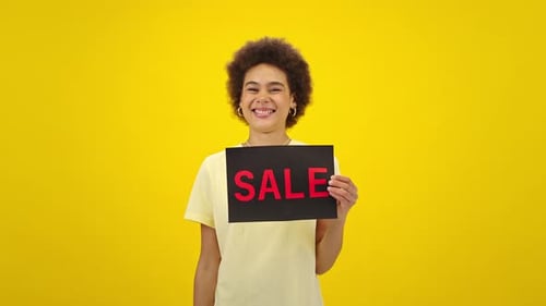 Woman Promotes Sales with Shopping Bags on Yellow
