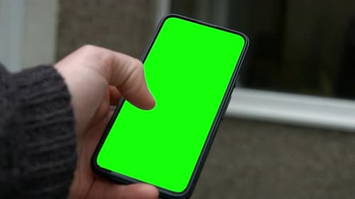 Male Hand Holding Smart Phone Green Screen Replacement with Thumb Swiping Through 4K