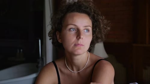 Thoughtful Woman with Curly Hair in Relaxing Setting