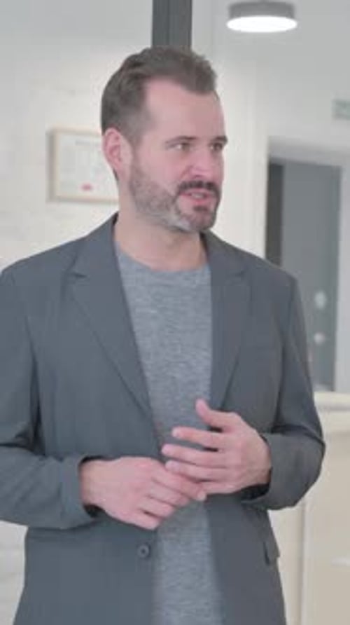 Professional Man Gesturing While Talking in an Office