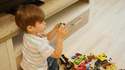 Boy Playing with Toy Cars on Floor