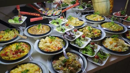 There are olive oil dishes and vegetables at the open buffet. 4k. slow motion.