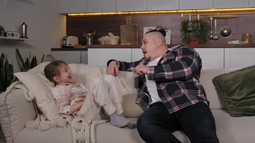 Father and Child Playing on Sofa at Home