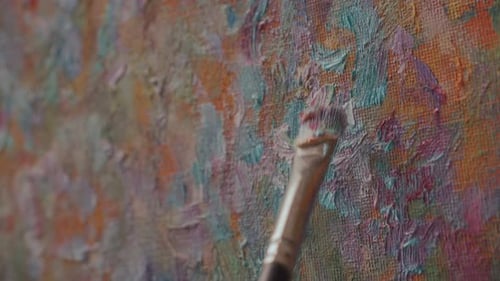 Close Up of Applying Thick Brushstrokes of Paint to Textured Canvas Surface