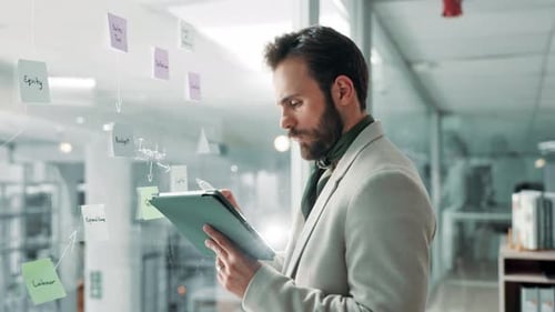 Bearded Man Planning on Glass in Modern Office