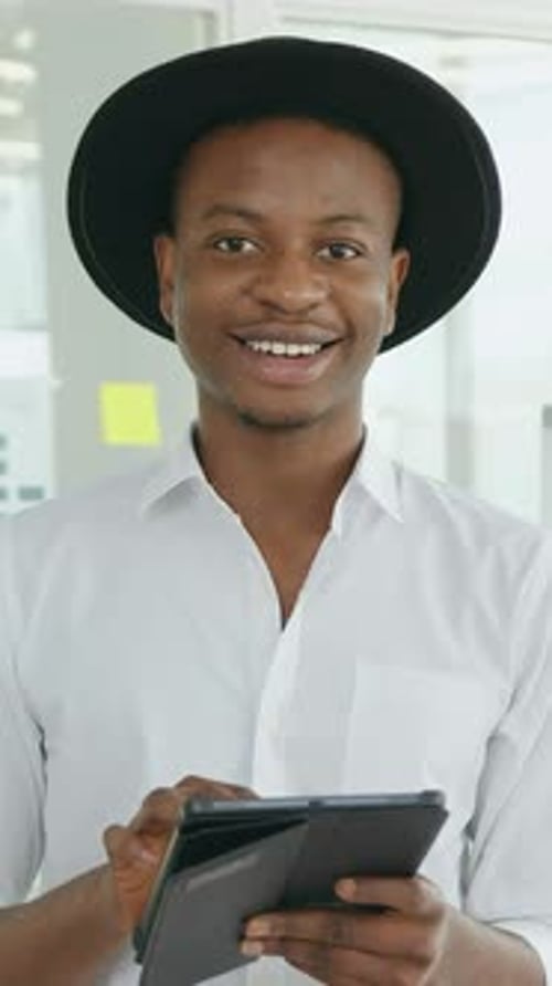 Smiling Man with Tablet Giving Thumbs Up in Office