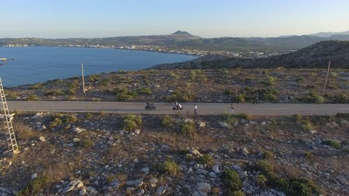 Touristes en cyclomoteur le long de la route avec la mer en arrière-plan. Prise de vue aérienne