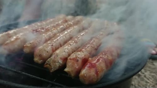 Top side view footage of delicious sausages an toast on hot barbecue.