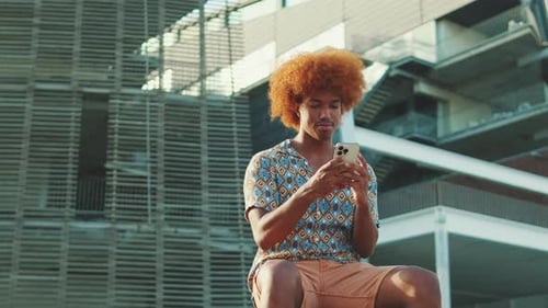 Man with Red Hair Using Smartphone in City