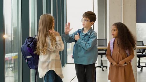 Happy Diverse Multiethnic Kids Junior School Students Group Giving High Five Together in Classroom
