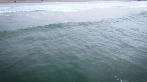 Aerial Shot Of One Surfer Riding Beautiful Long Wave On Sandy Beach , Peru