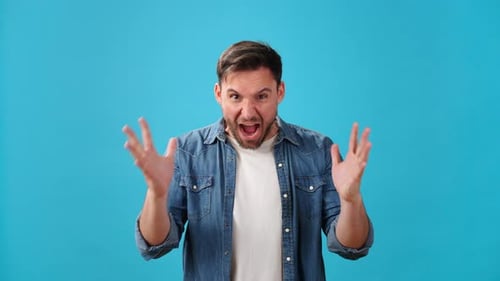 Angry Young Man Shouts and Shakes Head Threateningly