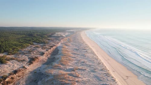 Une plage déserte de sable doré avec les vagues de l'océan qui déferlent sur le rivage chaud.