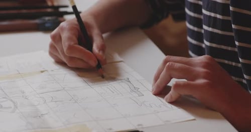 Drawing architectonic sketch of statue on squared paper with pencil.