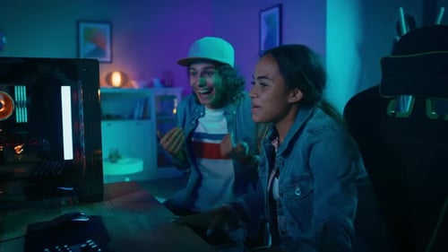 Excited young adults play video game in colorful room