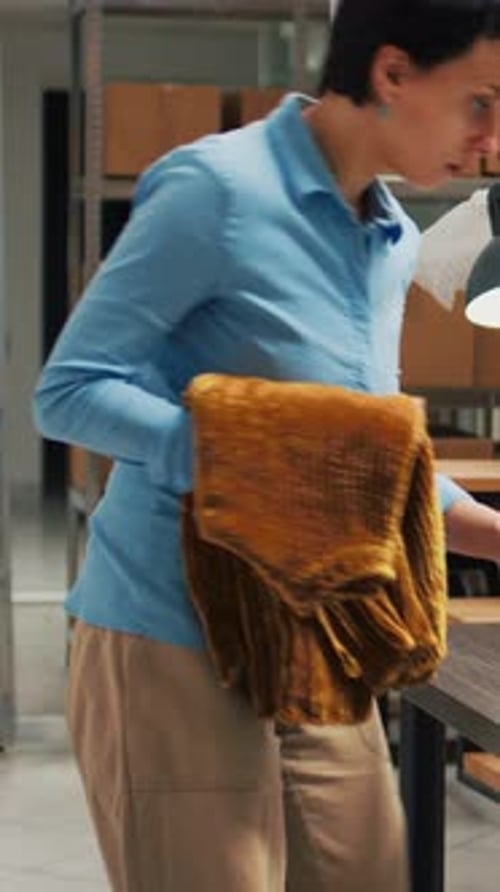Vertikales Video: Unternehmerin verwendet Lagermaterial, um es in Pappkartons zu packen