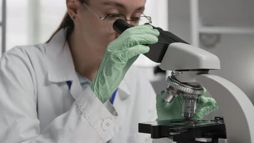 Woman Scientist Working with Microscope in Laboratory