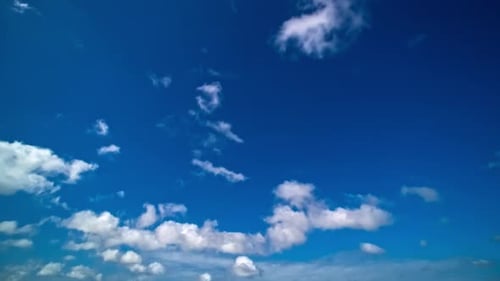 Fluffy White Clouds Drifting Across a Blue Sky