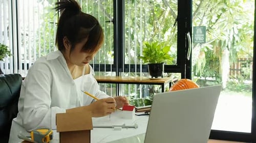 Female Architect Or Engineer use Vernier Caliper to measure the model house. Architectural Concept.