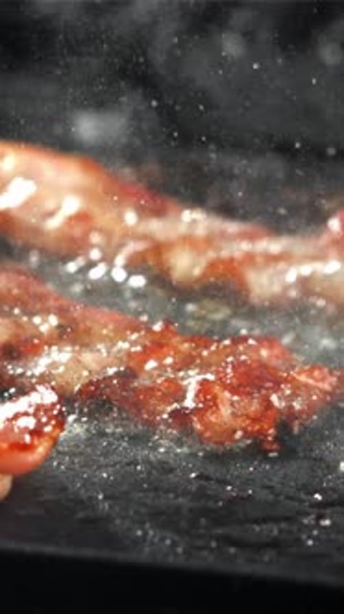 The Bacon is Fried in a Pan with a Splash of Oil Filmed on a Highspeed Camera at 1000 Fps