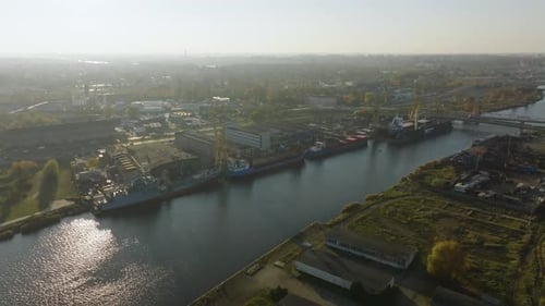 Aerial view of industrial shipyard with cranes and docked vessels