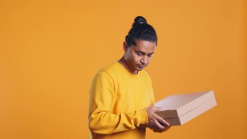 Porträt eines Pizzaboten, der Bestellungen zum Mitnehmen aus dem Thermorucksack nimmt