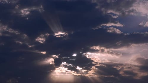 Sun Rays Streaming Through Cloudy Sky Over Ocean