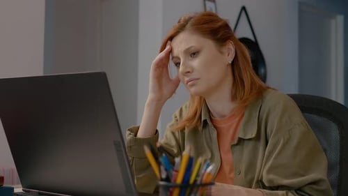 Woman Working at Computer Rubbing Temples