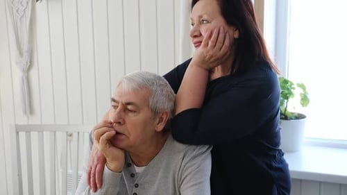 Loving senior couple embraces in bright indoor setting