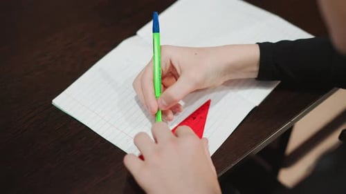 Overhead White Grandson Using Stencil and Pen Tracing Triangle on Dot Grid Notebook Hand