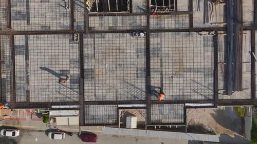 Aerial Video Aerial View of a Construction Site with Cranes Operating and Workers Managing Metal