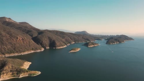 Aerial drone flying over a lake, water dam, with mountains at sunrise. Beautifull dreamy landscape v