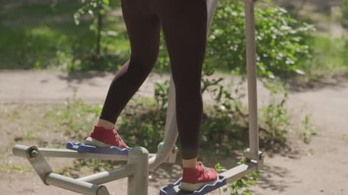 Woman Working Out on Outdoor Exercise Equipment in the Park