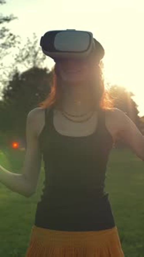 Vertical of Beautiful Caucasian Woman Enjoy Virtual Reality Walking on Grass in Park