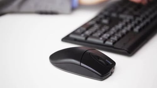 Hand Using Computer Mouse Next To Keyboard