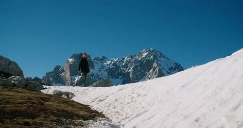 Male Traveler Walk on Top of Snowed Mountain on Winter Vacation Trip Enjoy View