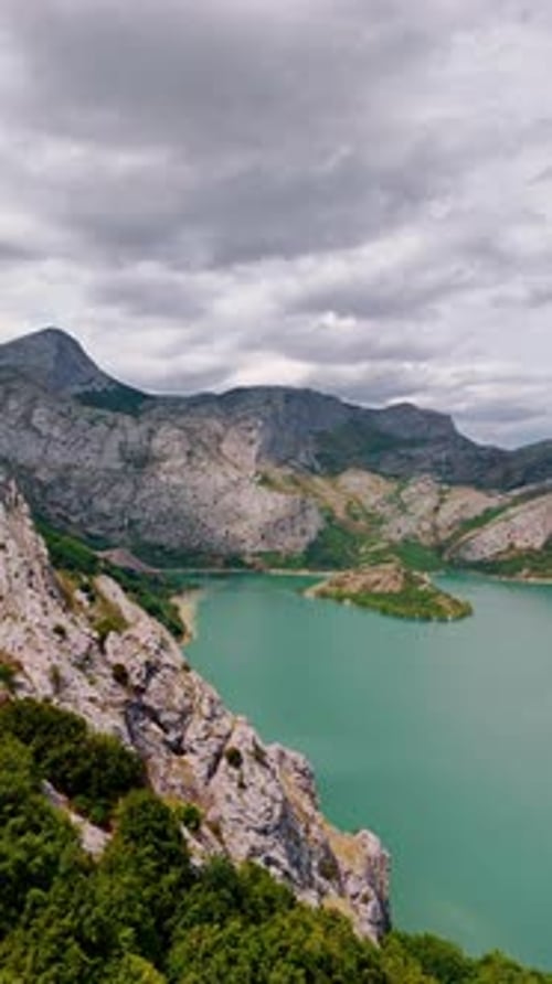 Dramatic sky above the stunning mountainous landscape. Bare rocks surround the turquoise lake.