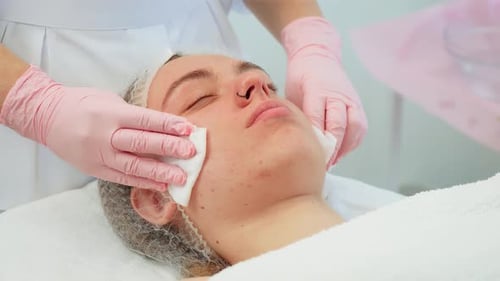 Woman Lying Relaxed While Gloved Hands Cleaning Face with Cotton Pads Female Receiving Facial