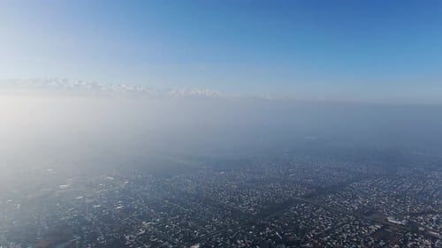 Aerial view of polluted city covered with smog