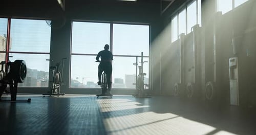 Stationary bike, training and fitness with woman in gym for cardio, exercise machine and health