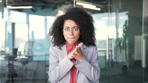 Webcam view. Angry african american businesswoman in a suit arguing talking on a video call sitting