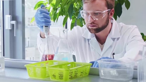 Scientist uses Pipette in Medical Research Laboratory