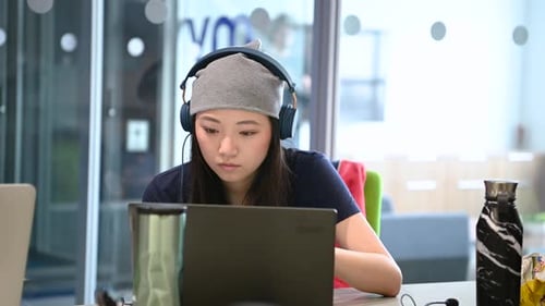 Focused young woman working on laptop in office
