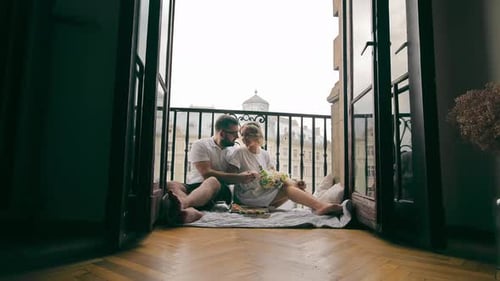 Romantic Couple Enjoying Balcony Picnic in the City