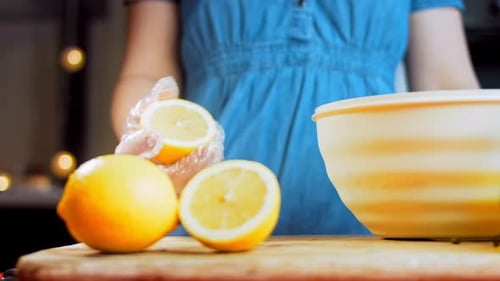 Woman Squeezing Lemon Juice Into a Bowl