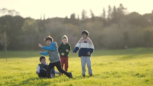 Children Playing and Laughing Together in a Park at Sunset