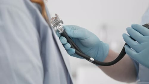 Doctor Listens to Patient Heartbeat with Stethoscope