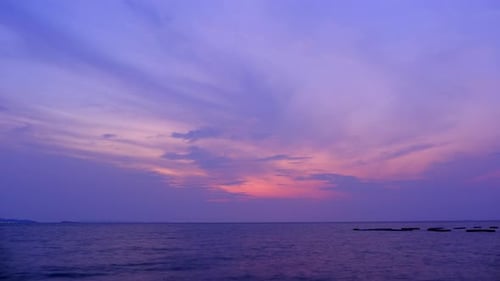 Dämmerungs- und Morgendämmerungshimmel mit Cumuluswolke im Zeitraffer am Meer in abendlichen 4K-Aufnahmen.