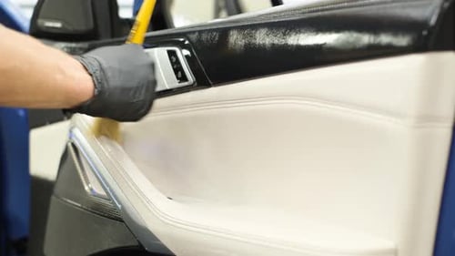 Gloved Hand Details Car Interior with Brush
